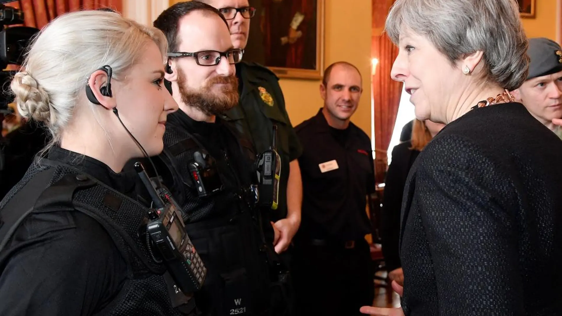 La primera ministra británica Theresa May habla con las primeras personas que atendieron al ex oficial de inteligencia ruso Sergei Skripal y su hija Yulia