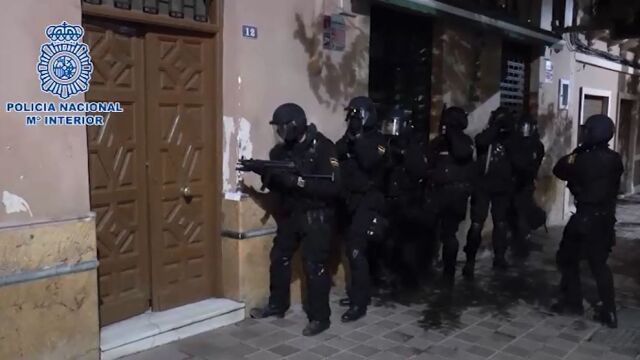 Varios agentes proceden a entrar en una de las viviendas registradas
