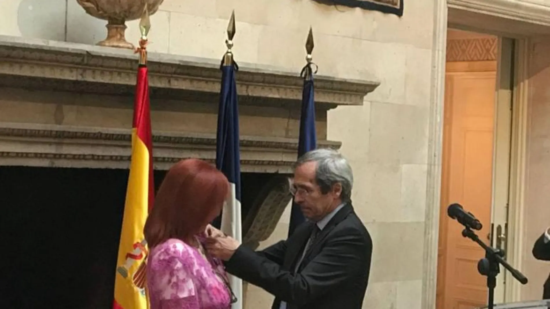 Instante en el que el embajador francés Yves Saint-Geours, impone la Medalla de Caballero de la Orden del Mérito de la República Francesa a la periodista, académica y escritora española Karmen Garrido.
