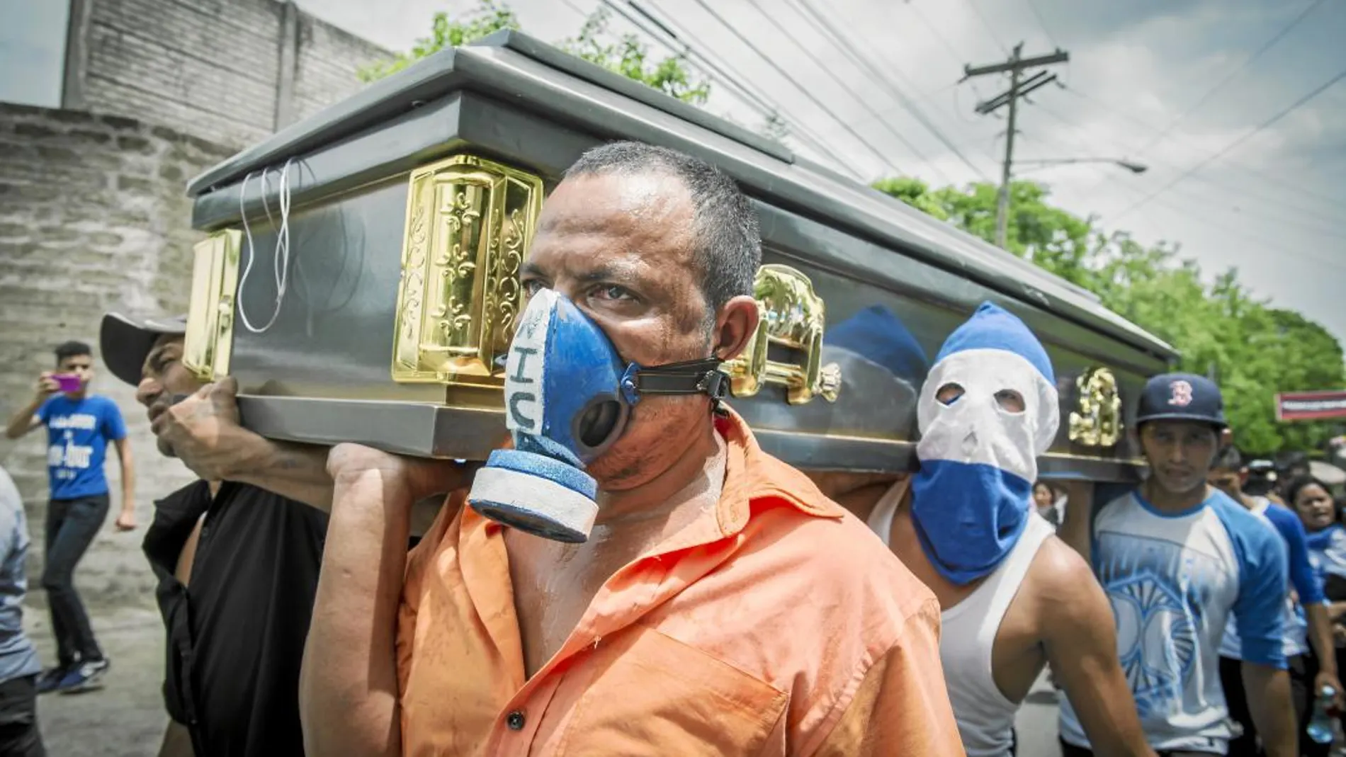Amigos de una de los manifestantes muertos en Nicaragua trasladan su féretro durante el funeral