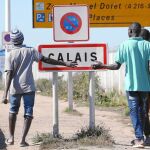 Tres refugiados en la entrada de «La Jungla de Calais»