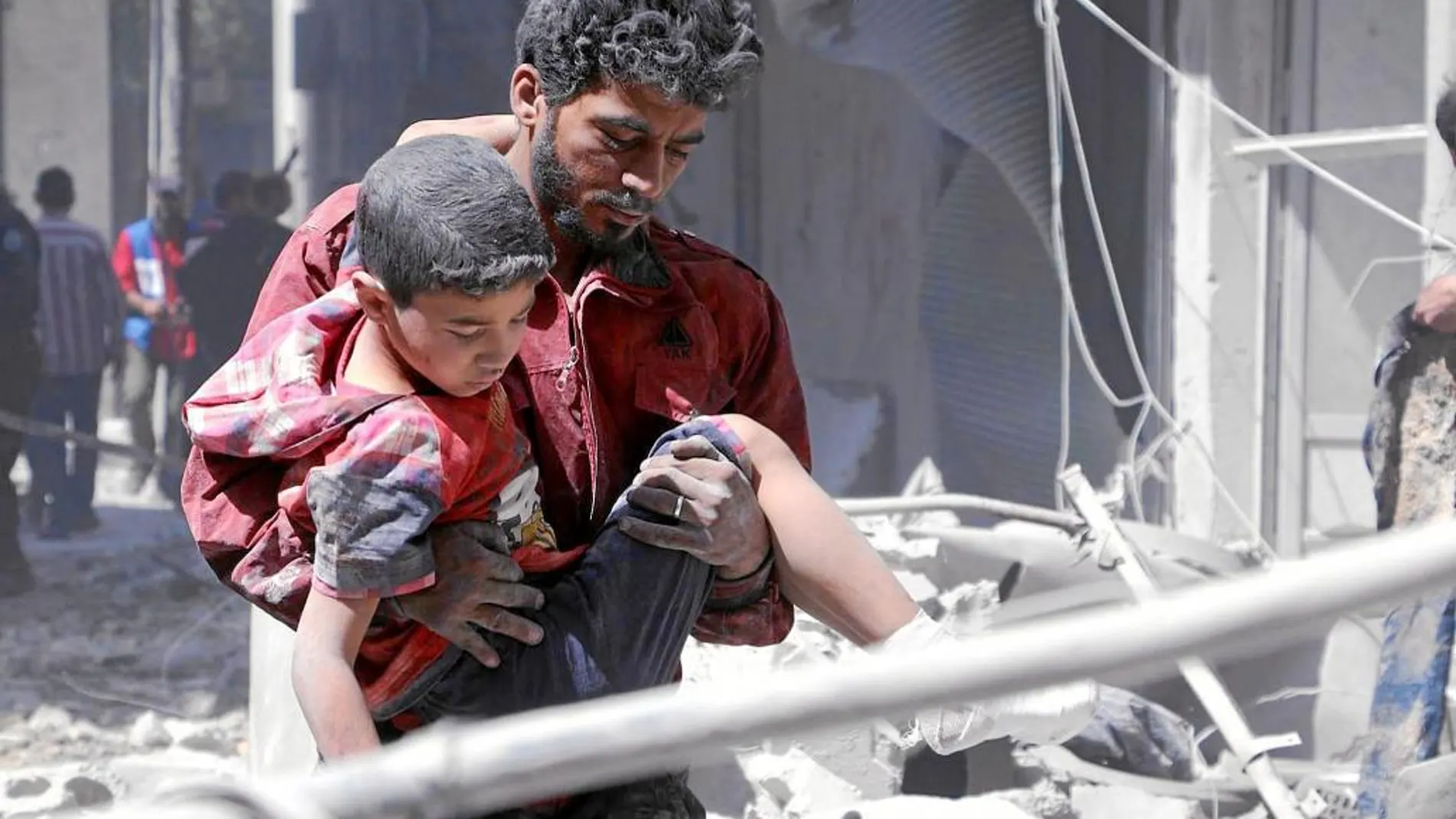 Un hombre rescata a un niño de los escombros de Alepo tras un bombardeo