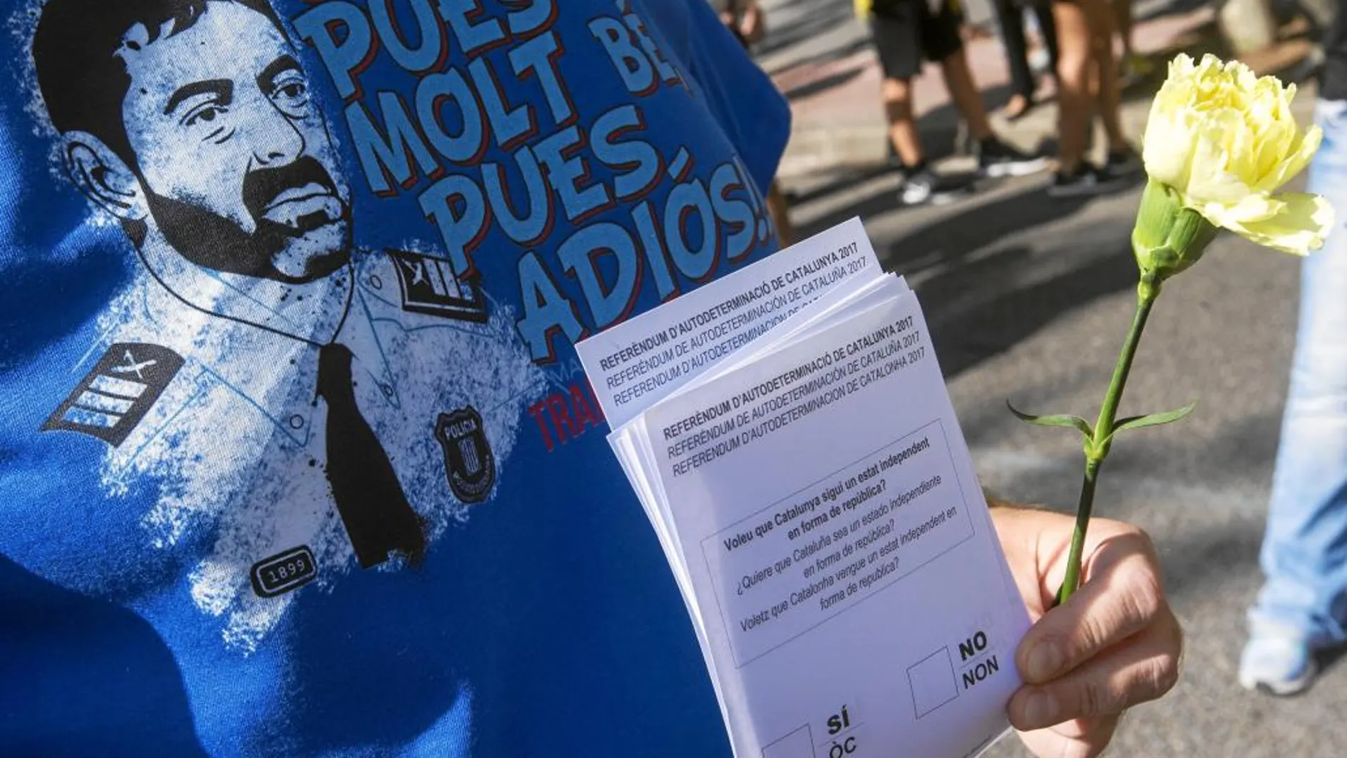 Una persona con la camiseta del Mayor de los Mossos y papeles del referéndum, ayer en Barcelona