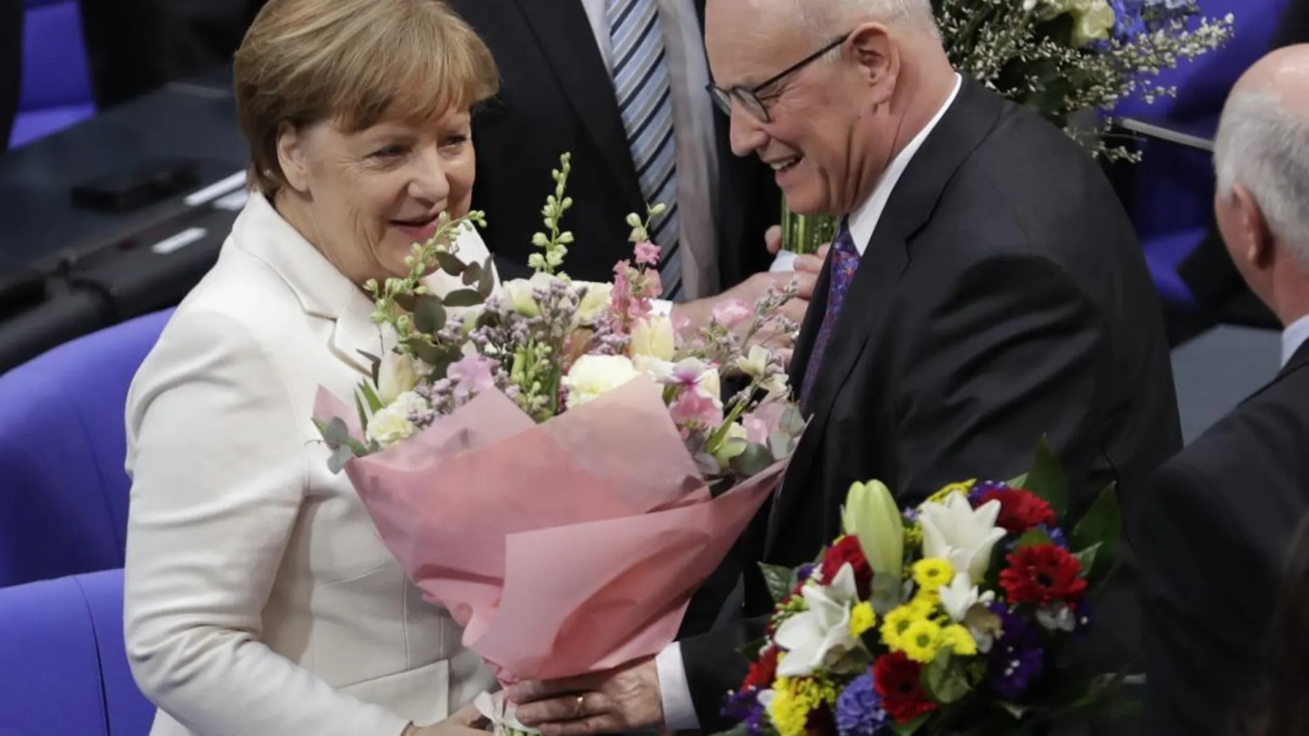 Angela Merkel recibe flores del líder de los demócratas cristianos Volker Kauder