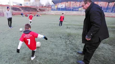 Gonzalo Ruipérez, el párroco de San Juan de Dios, junto a los niños de las familias a las que ayuda en el barrio de Santa Eugenia