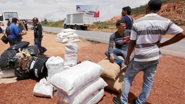 Un grupo de venezolanos que ha viajado hasta Paracaima (Brasil) en busca de víveres, llega a la estación de Santa Elena, en Venezuela