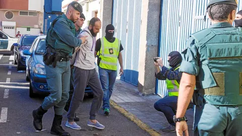 Agentes de la Guardia Civil conducen al presunto yihadista detenido, que vivía en la localidad canaria de Vecindario, para la realización de un registro