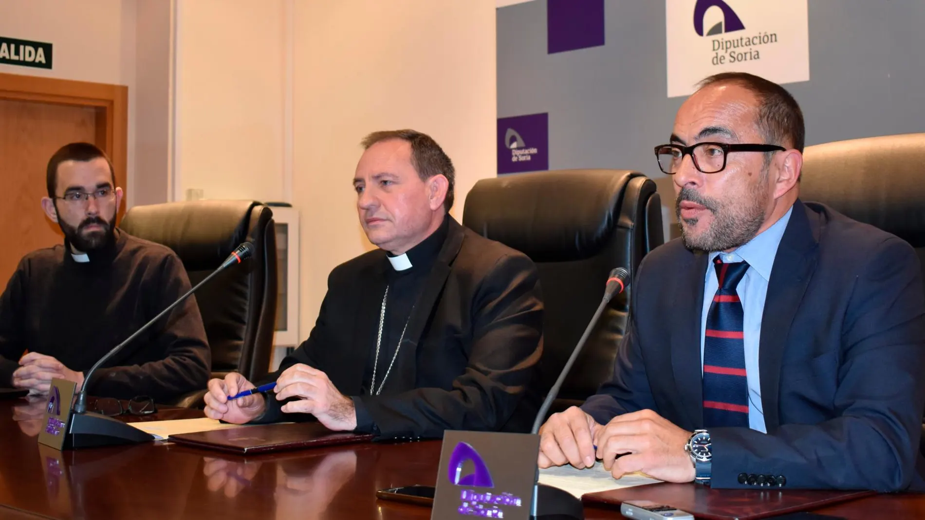 El presidente de la Diputación, Luis Rey, y el obispo de Osma-Soria, Abilio Martínez, suscriben el acuerdo de colaboración en presencia de Rubén Tejedor