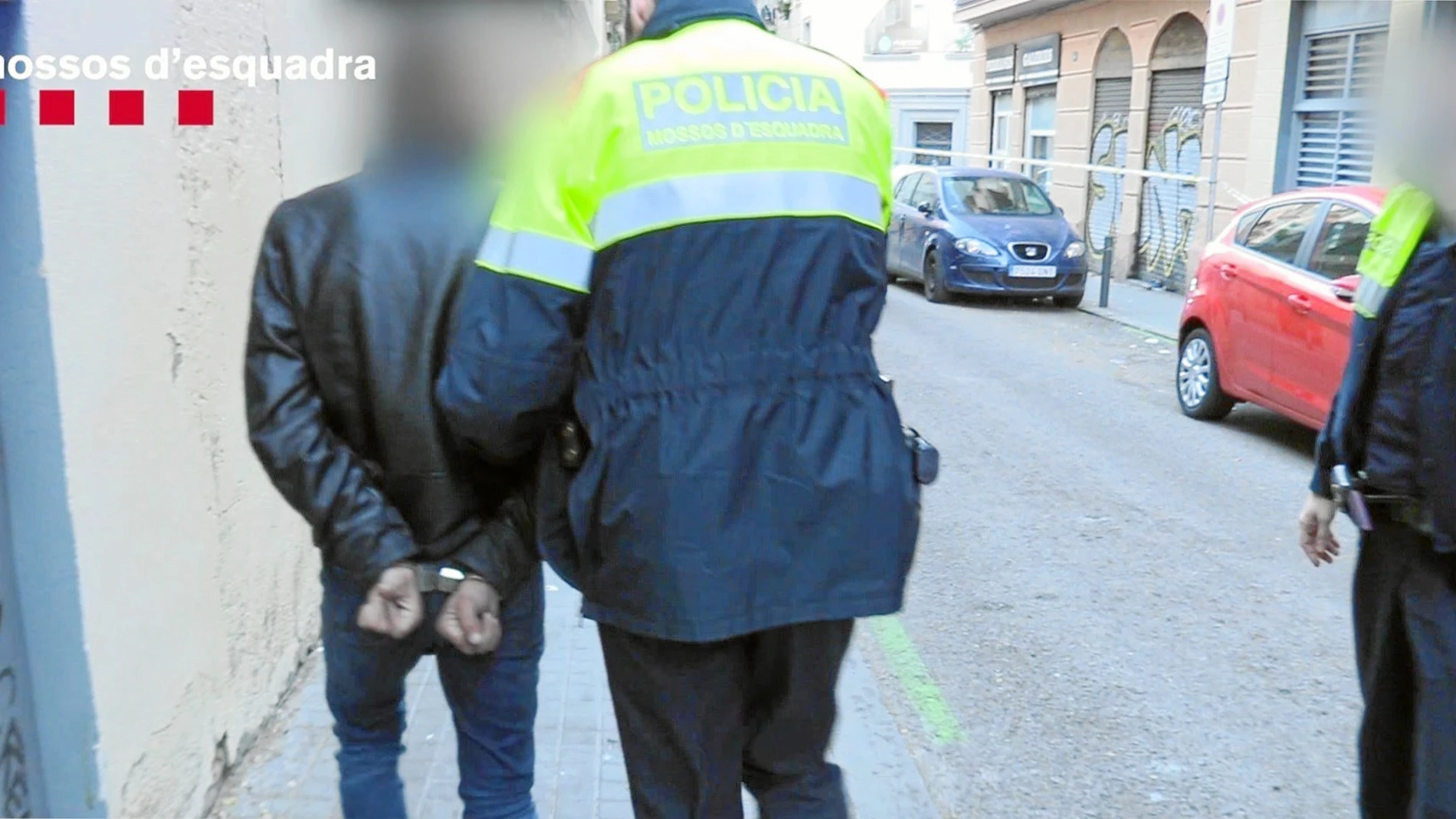En la imagen, un momento de la operación de ayer contra los narcopisos, con un agente de los Mossos trasladando a uno de los cuatro detenidos