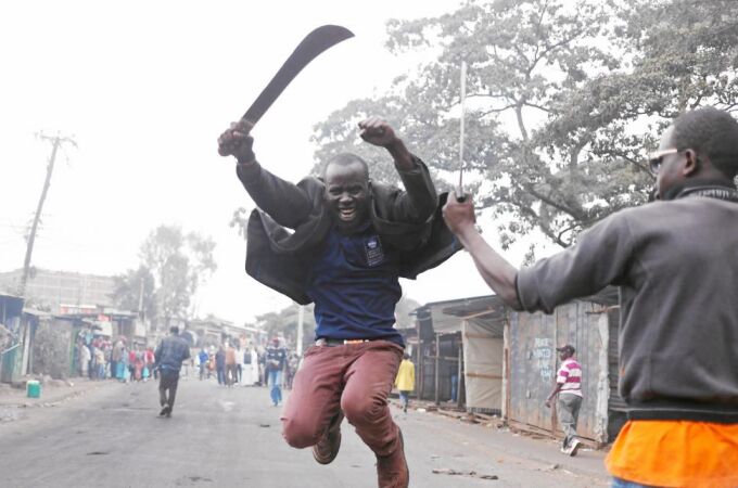 Un simpatizante del líder de la oposición, Raila Odinga, gesticula con un machete en una barriada en Kibera, ayer, en Nairobi