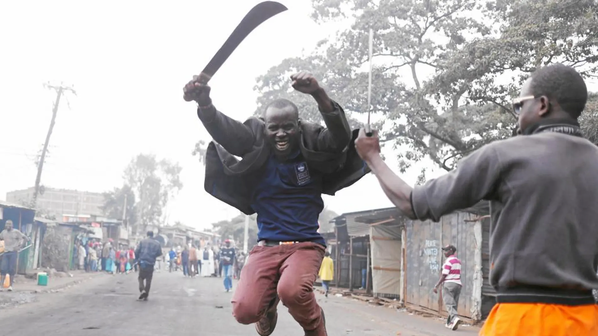 Un simpatizante del líder de la oposición, Raila Odinga, gesticula con un machete en una barriada en Kibera, ayer, en Nairobi