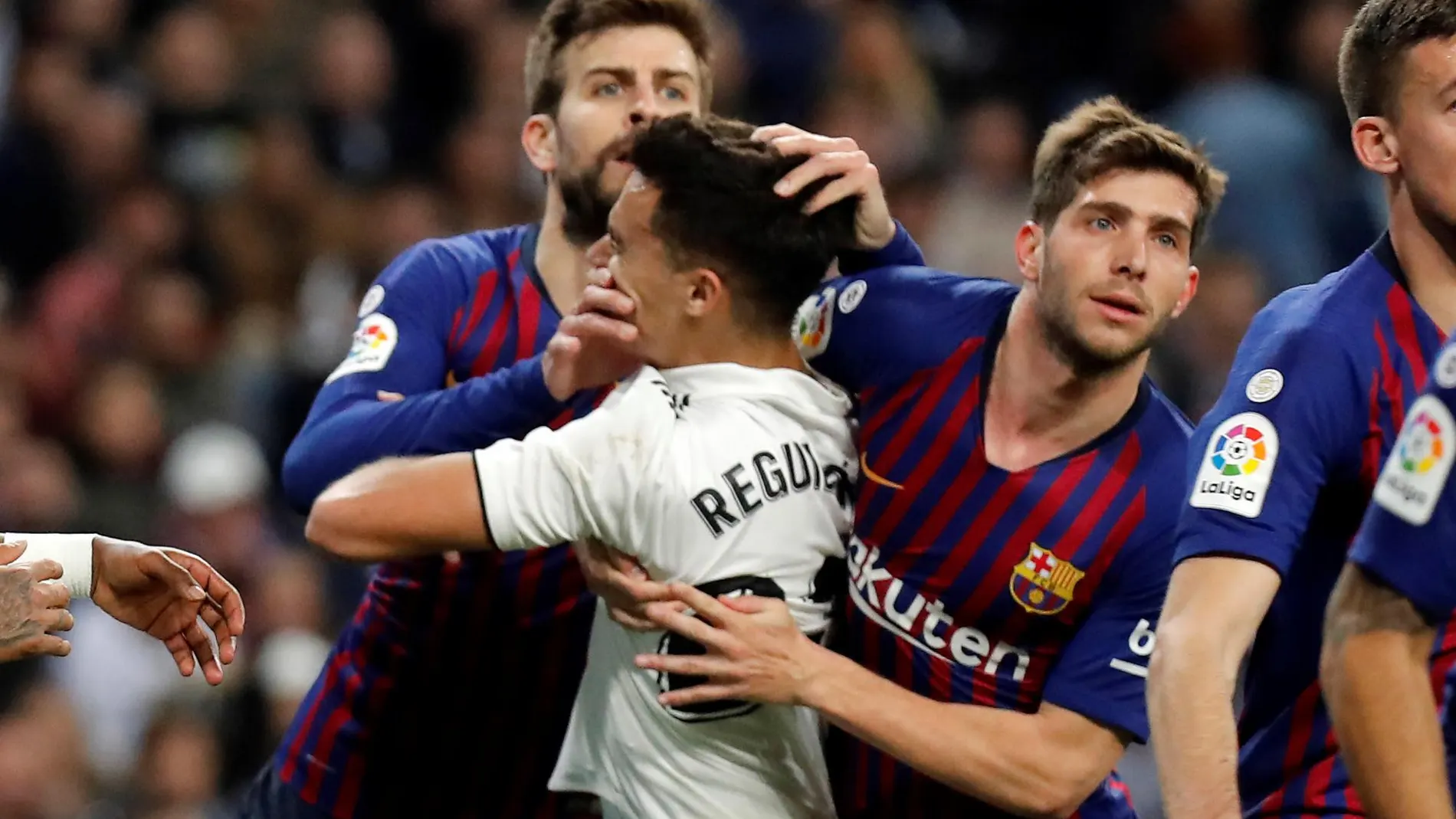 El defensa del Real Madrid Sergio Reguilón lucha con Piqué