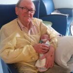 Imagen de David, el «abuelo de la UCI», con un bebé en sus brazos en la UCI pediátrica