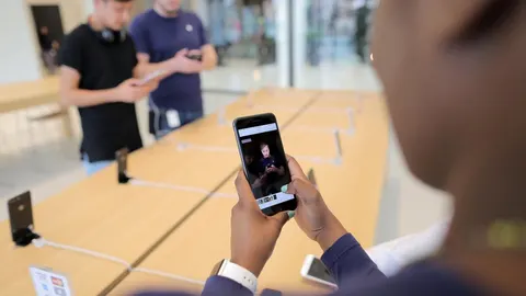 Un usuario con un iPhone 8 en la mano.