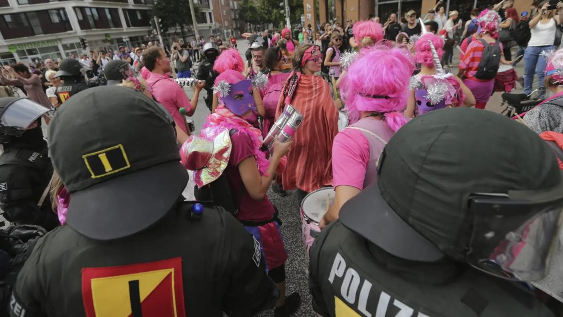 Agentes antidisturbios desalojan a un grupo de manifestantes disfrazados durante una protesta contra la celebración de la cumbre del G20 frente a la estación de Schlump en Hamburgo (Alemania)