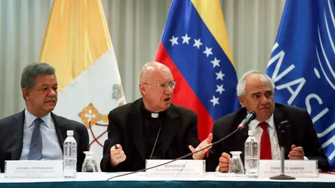 Monseñor Claudio Maria Celli, portavoz del Vaticano, habla entre el ex presidente dominicano Leonel Fernandez y Ernesto Samper.