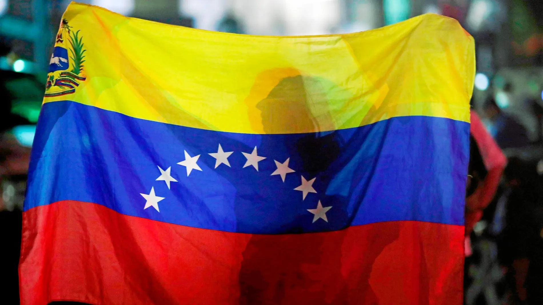 Una mujer sostiene una bandera en la vigilia celebrada el pasado domingo en Caracas por las víctimas de la represión / Reuters