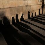 Sombras de votantes que hacen fila frente a un colegio electoral de Barcelona para ejercer el derecho al voto en estas autonómicas