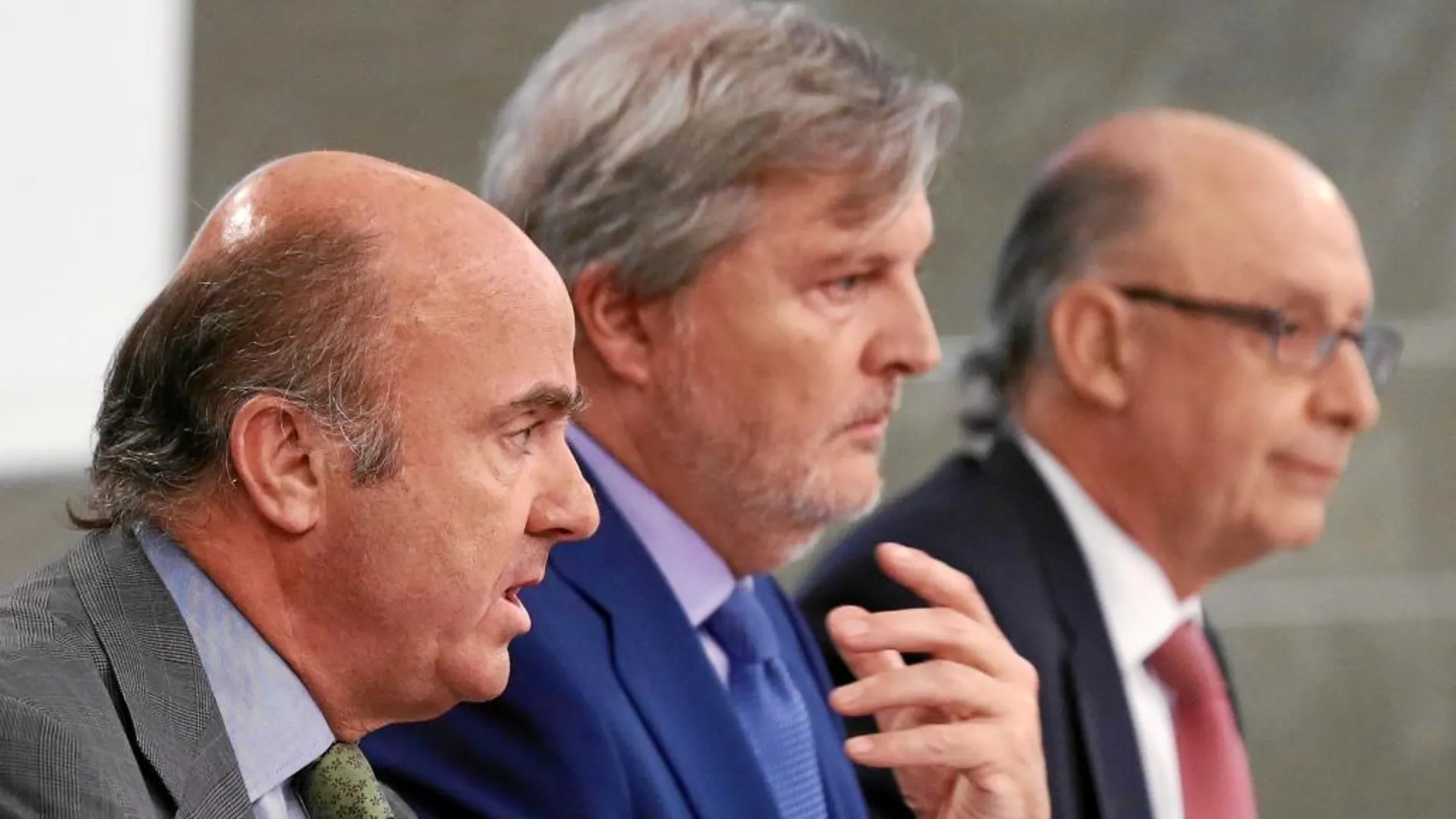 De izda. a dcha., Luis de Guindos, Íñigo Méndez de Vigo y Cristóbal Montoro, ayer, en rueda de prensa tras el Consejo de Ministros