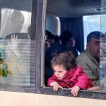 Un niña mira desde un autobús durante la evacuación de civiles en la ciudad siria de Duma