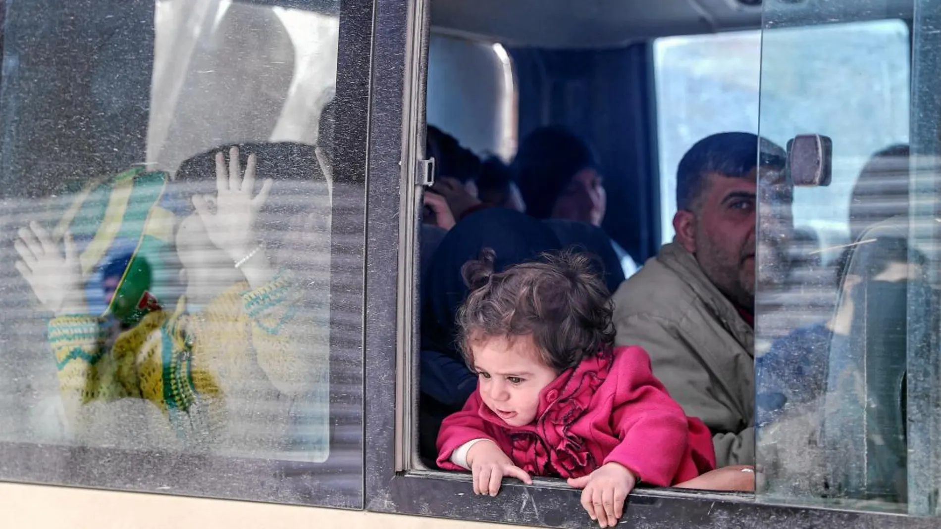 Un niña mira desde un autobús durante la evacuación de civiles en la ciudad siria de Duma