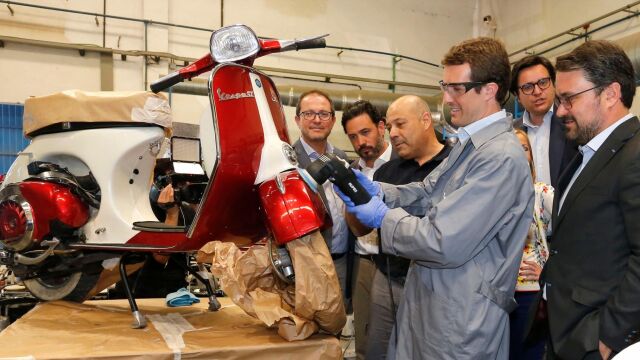 El líder del PP y candidato a presidente del Gobierno, Pablo Casado, pule la carcasa de una vespa
