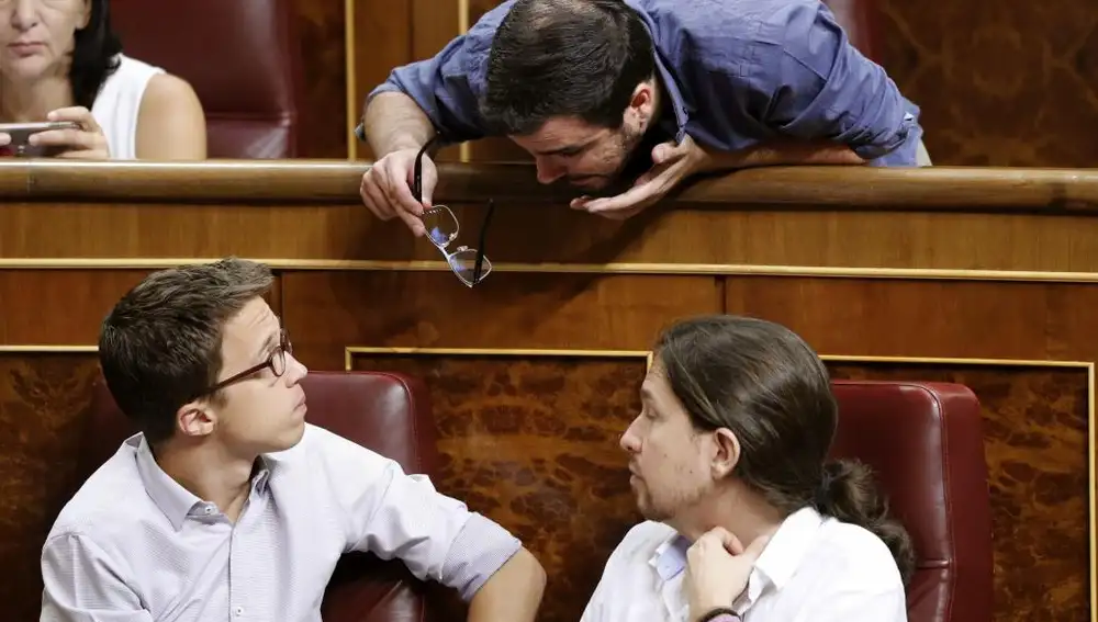 El secretario general de Podemos, Pablo Iglesias (d); el portavoz del Grupo Podemos-En Comú-En Marea, Íñigo Errejón (i), y el coordinador federal de Izquierda Unida, Alberto Garzón, conversan durante la sesión constitutiva de las Cortes Generales de la XII Legislatura