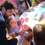 Imagen de López Miras con los niños que asisten al campamento de Cáritas