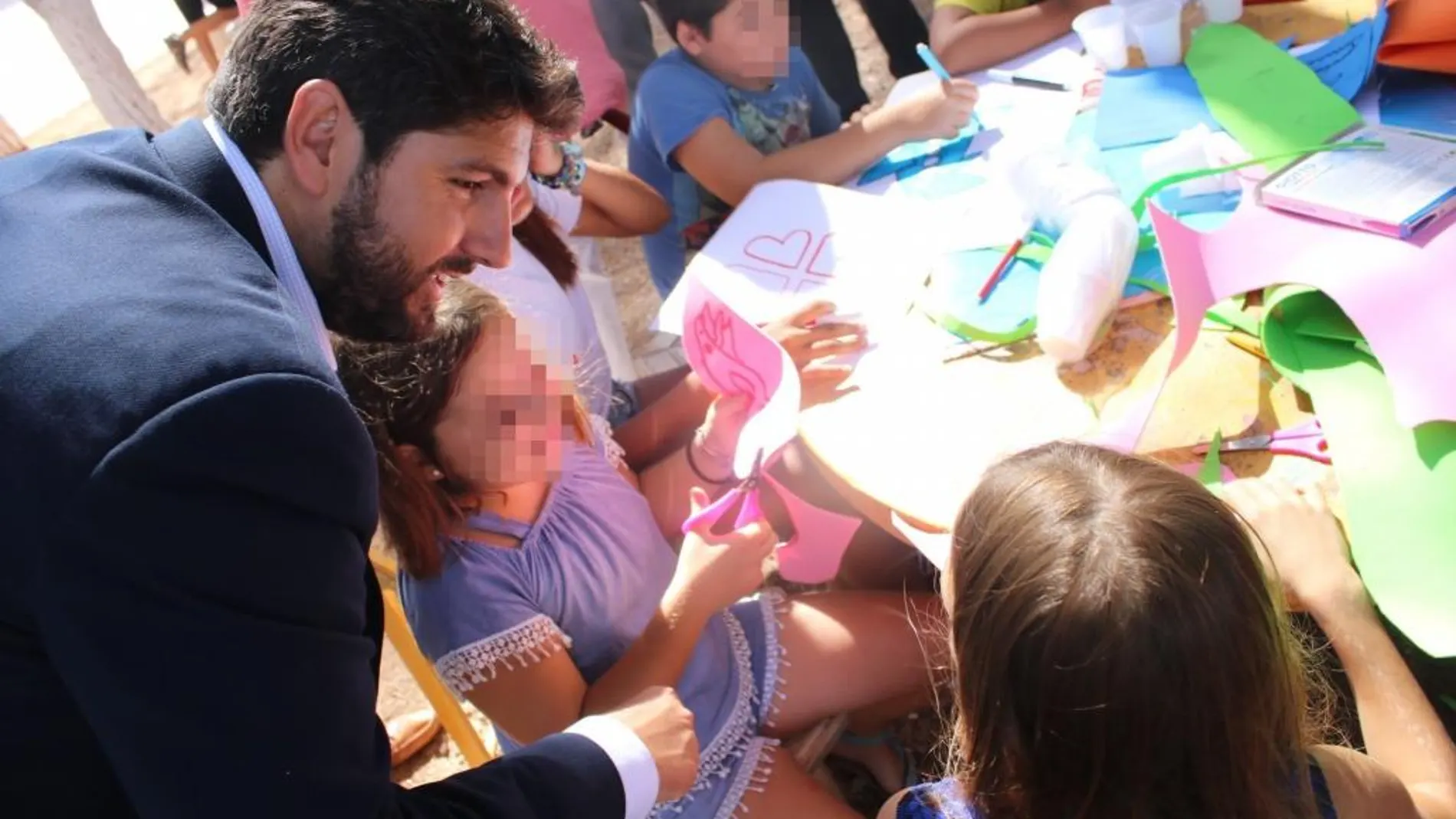 Imagen de López Miras con los niños que asisten al campamento de Cáritas