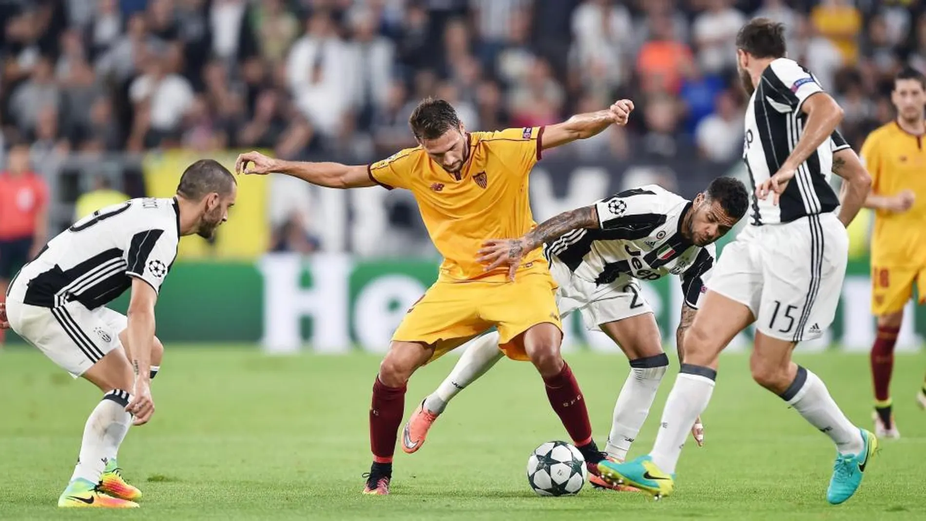 El jugador del Sevilla Franco Vazquez (ci) disputa el balón con Dani Alves (cd) del Juventus