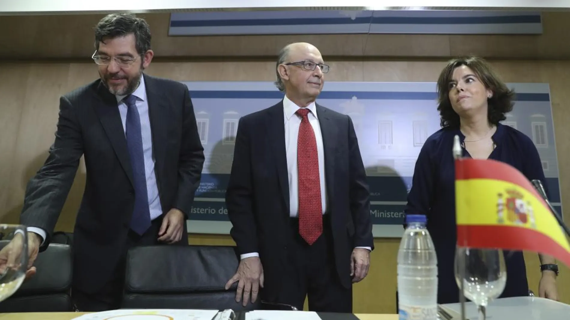 El ministro de Hacienda, Cristóbal Montoro (c), la vicepresidenta del Gobierno, Soraya Sáenz de Santamaría, y el secretario de Estado de Presupuestos, Alberto Nadal (i).