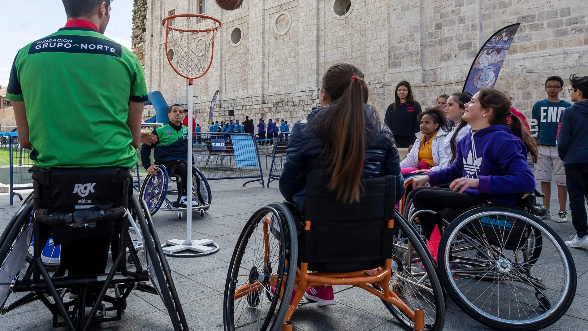 Un grupo de escolares juega al baloncesto en silla de ruedas con miembros del equipo de la Fundación Grupo Norte