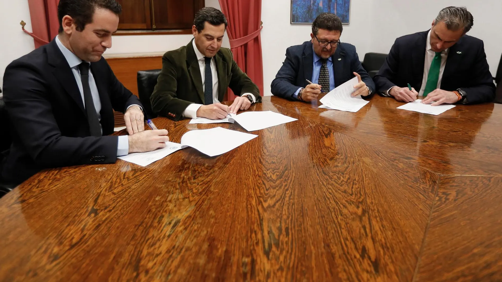 Teodoro García Egea y Javier Ortega Smith firman junto a Juanma Moreno y Francisco Serrano, el acuerdo. EFE/Jose Manuel Vidal.