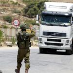 Un soldado israelí hace parar a una furgoneta palestina en la entrada de las fronteras de Saeer
