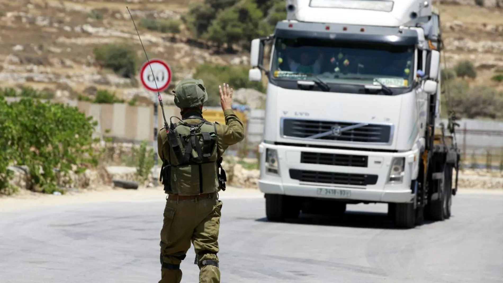 Un soldado israelí hace parar a una furgoneta palestina en la entrada de las fronteras de Saeer