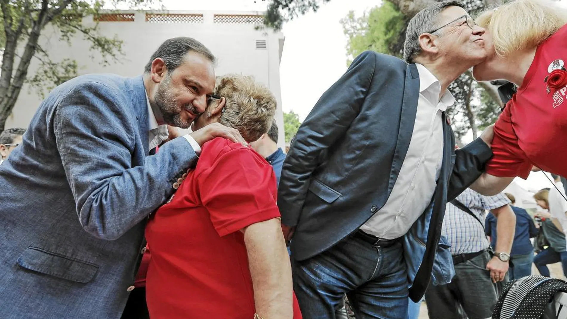El secretario de Organización del PSOE, José Luis Ábalos, junto al de Valencia, Ximo Puig, saludan ayer a unas militantes del partido en la Fiesta de la Rosa celebrada en Torrente (Valencia)