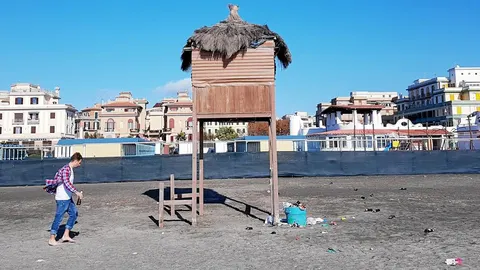 Un joven pasea por la playa de Ostia, donde residen 200.000 personas y uno de los destinos vacacionales favoritos de los urbanitas romanos