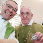 El párroco Nandino Capovilla, junto al Papa, quien sostiene la chapa “Abramos los puertos”