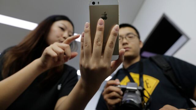 Dos clientes chinos prueban un iPhone en Pekín / Reuters