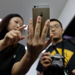 Dos clientes chinos prueban un iPhone en Pekín / Reuters
