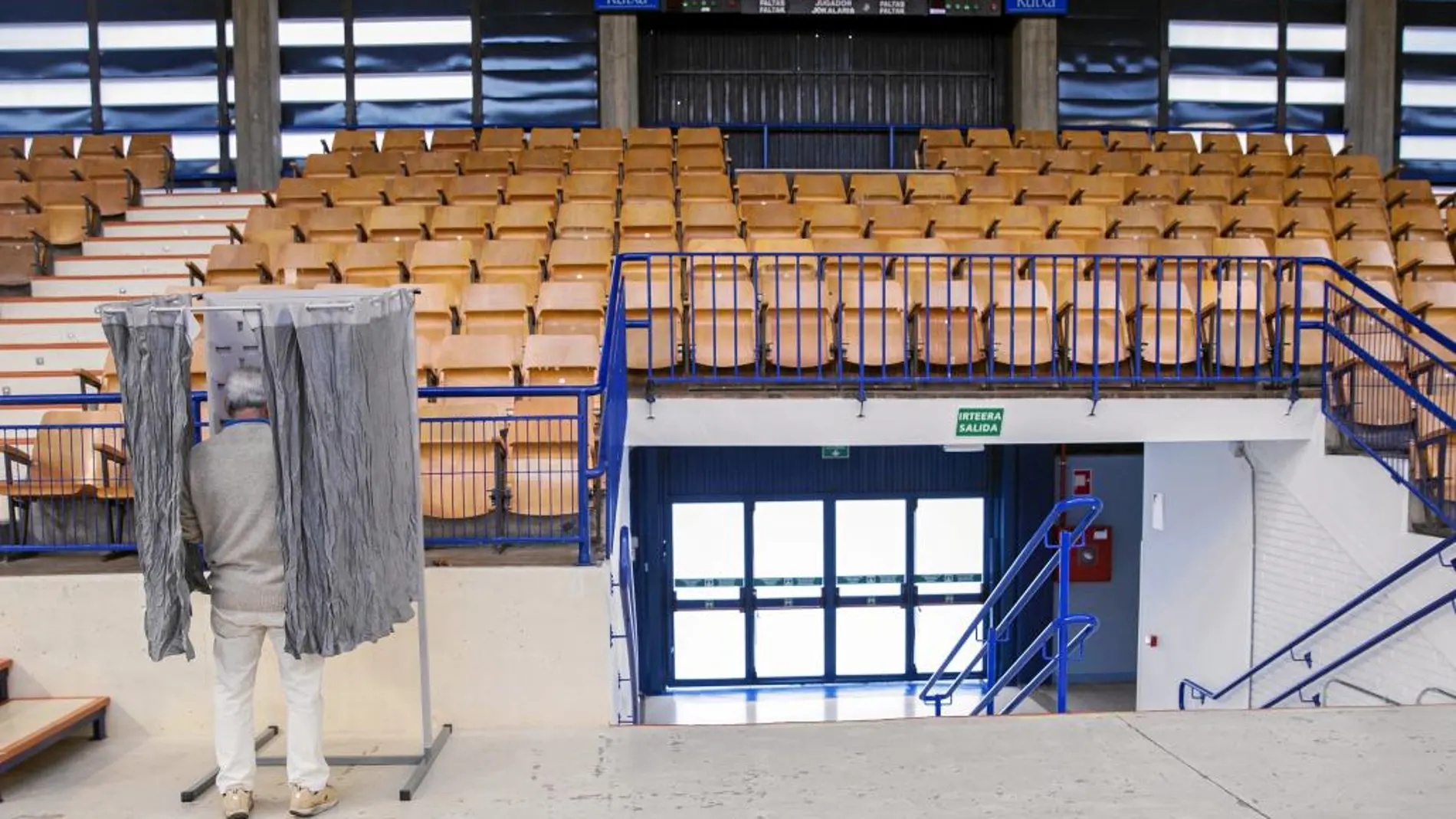 Un ciudadano deposita su papeleta en un polideportivo habilitado como colegio electoral en Vitoria