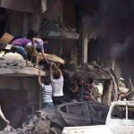 Fotografía facilitada por la Agencia Oficial de Noticias siria, SANA, que muestra a varias personas mientras trasladan un cuerpo tras la explosión de una bomba en Qameshli, Siria