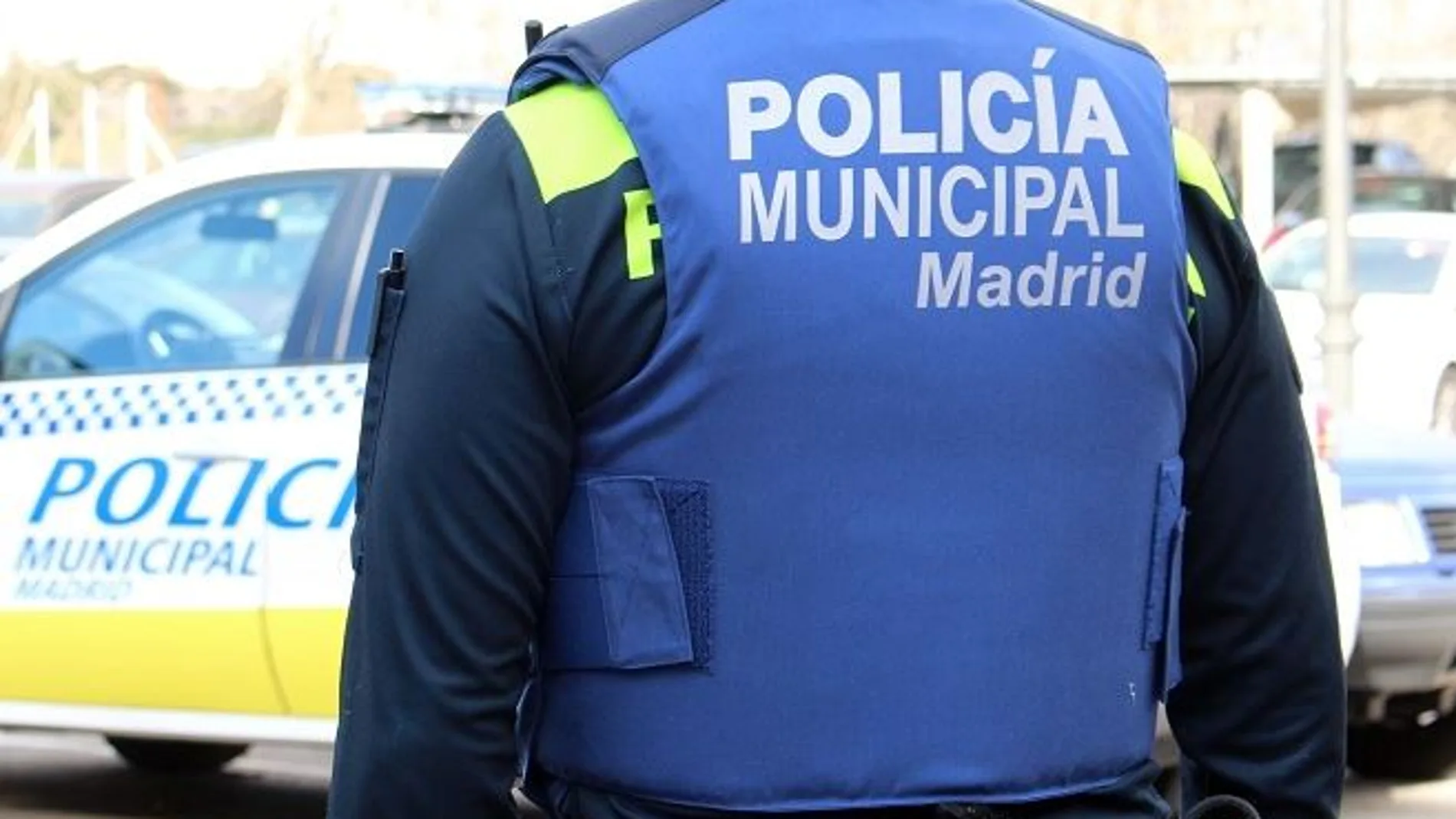 Un agente y un vehículo de la Policía Municipal de Madrid 