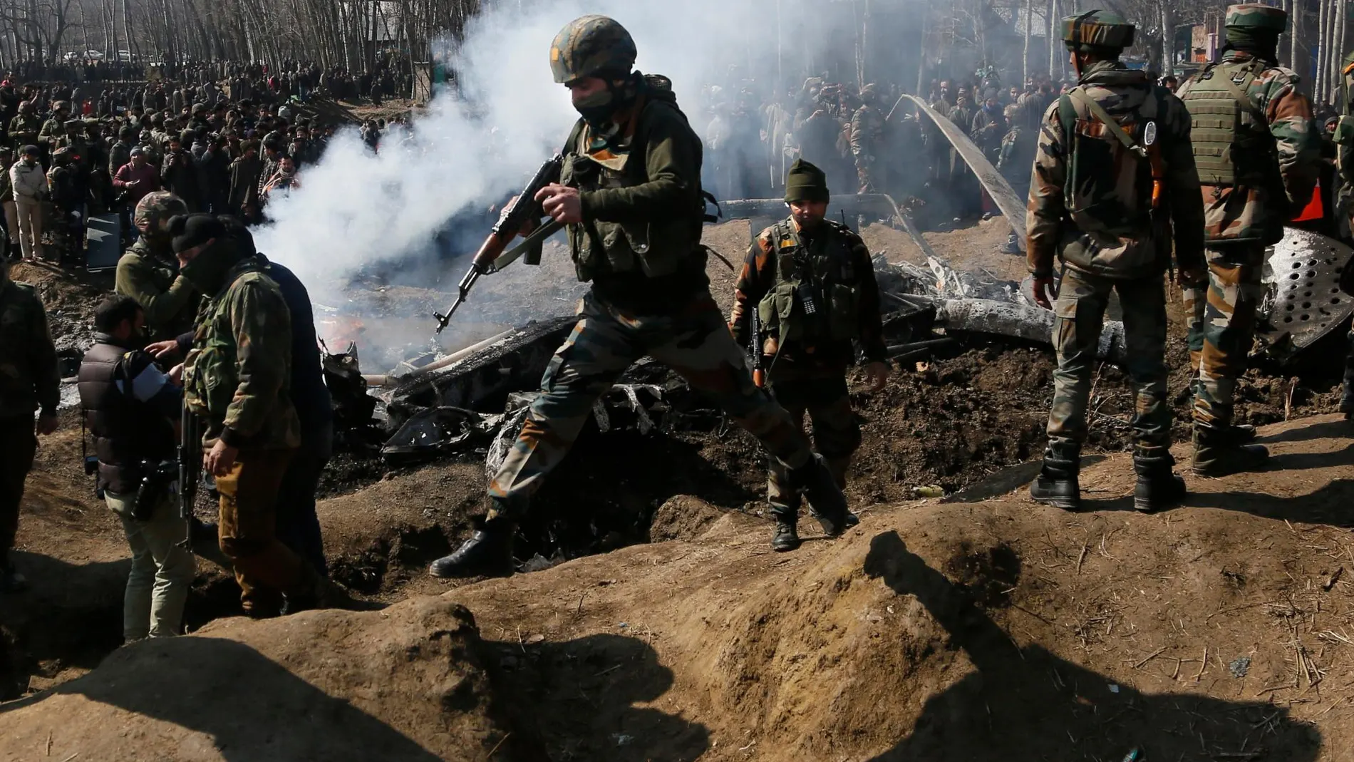 Soldados indios llegan al lugar en que ha sido derribado un avión indio. (AP Photo/Mukhtar Khan)