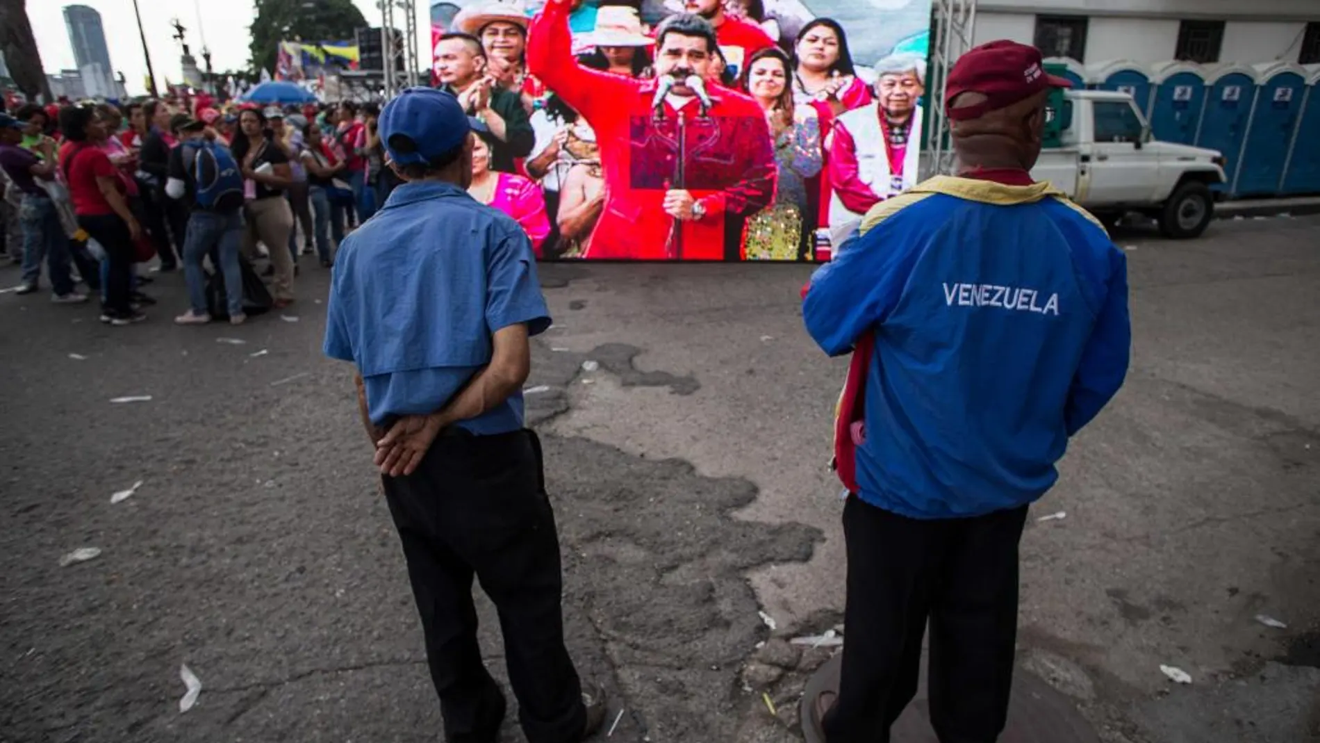 Simpatizantes del presidente de Venezuela Nicolás Maduro observan al presidente pronunciar un discurso en un acto el martes 12 de octubre de 2016, en Caracas (Venezuela).