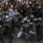 Agentes antidisturbios de la Policía Nacional forman un cordón de seguridad frente al colegio Ramón Llull de Barcelona