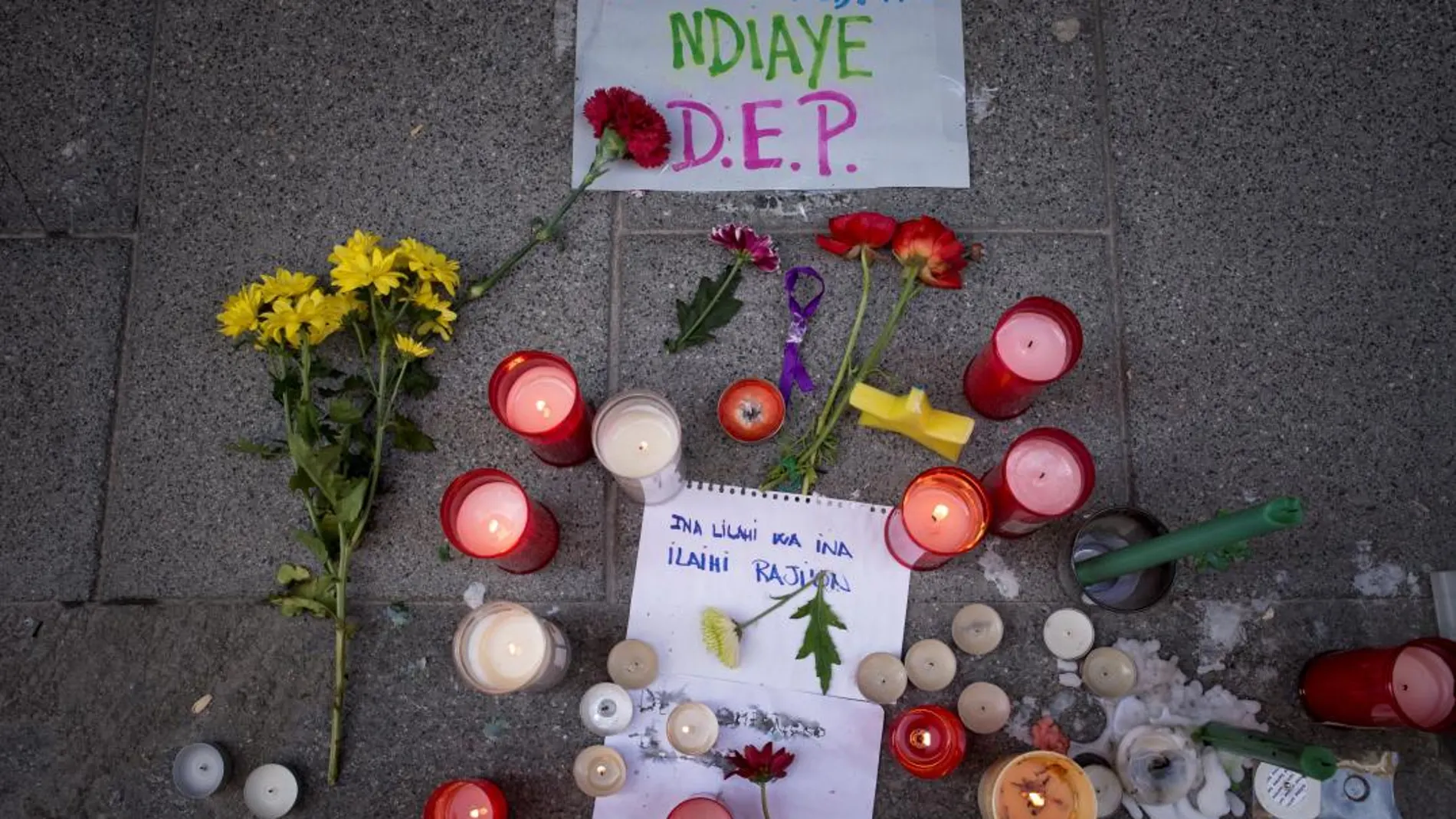 Flores, velas y demás recordatorios en memoria de Mmame Mbage en el lugar en el que se produjo su muerte anoche en el barrio de Lavapiés (Madrid).