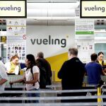 Un grupo de pasajeros ante un mostrador de facturacion de Vueling en el Aeropuerto de Barcelona-El Prat / Foto: Efe