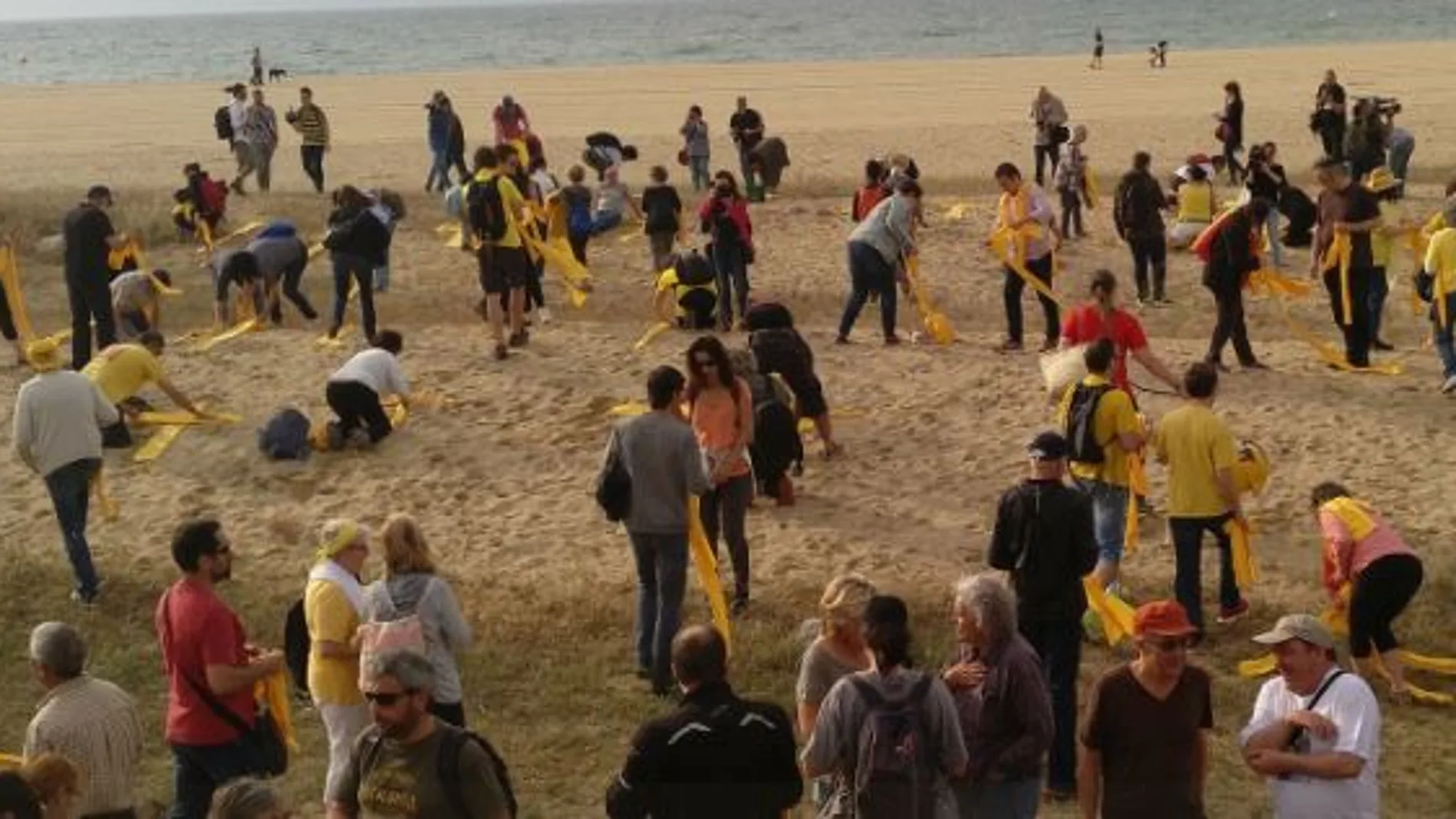 Un centenar de personas colocan toallas amarillas en forma de cruces en las playas de Mataró. Foto: Twitter