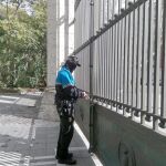 Un policía municipal procede al cierre de la entrada principal